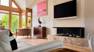 Living area with a stone fireplace surround and oak flooring