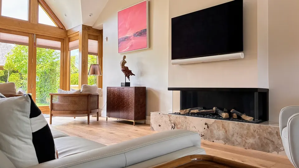Broadway — May 2026 Project — interior living area with stone fireplace and vaulted ceiling
