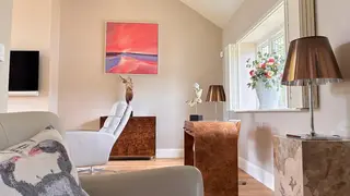 Finished sitting room with neutral walls and oak flooring