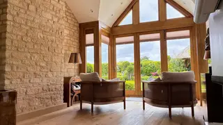 Vaulted living room with exposed stone wall and glazed doors