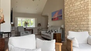 Living room with an exposed stone feature wall and grey seating