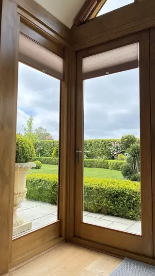 Garden seen through full-height glazed doors