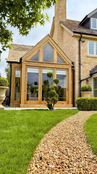 Accoya-clad steel-framed extension with clipped topiary in the foreground