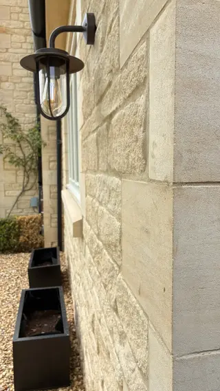 Close view of a white window set into the stone wall