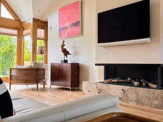 Living area with a stone fireplace surround and oak flooring