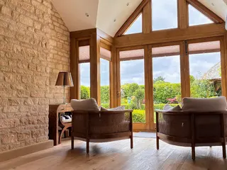 Vaulted living room with exposed stone wall and oak-framed doors