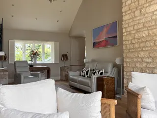 Living room with an exposed stone feature wall and grey seating