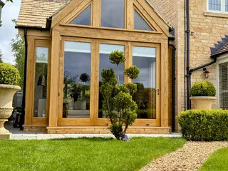 Oak-framed extension with clipped topiary in the foreground