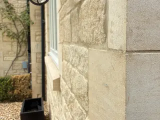 Close view of a white window set into the stone wall